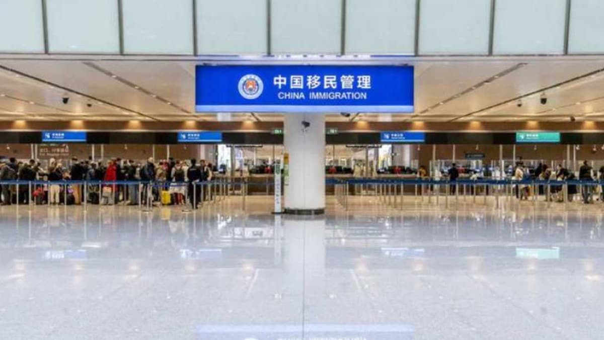 Hall d'inspection de l'immigration chinoise dans un aéroport chinois, avec des files de passagers arrivant sous un panneau bleu China Immigration