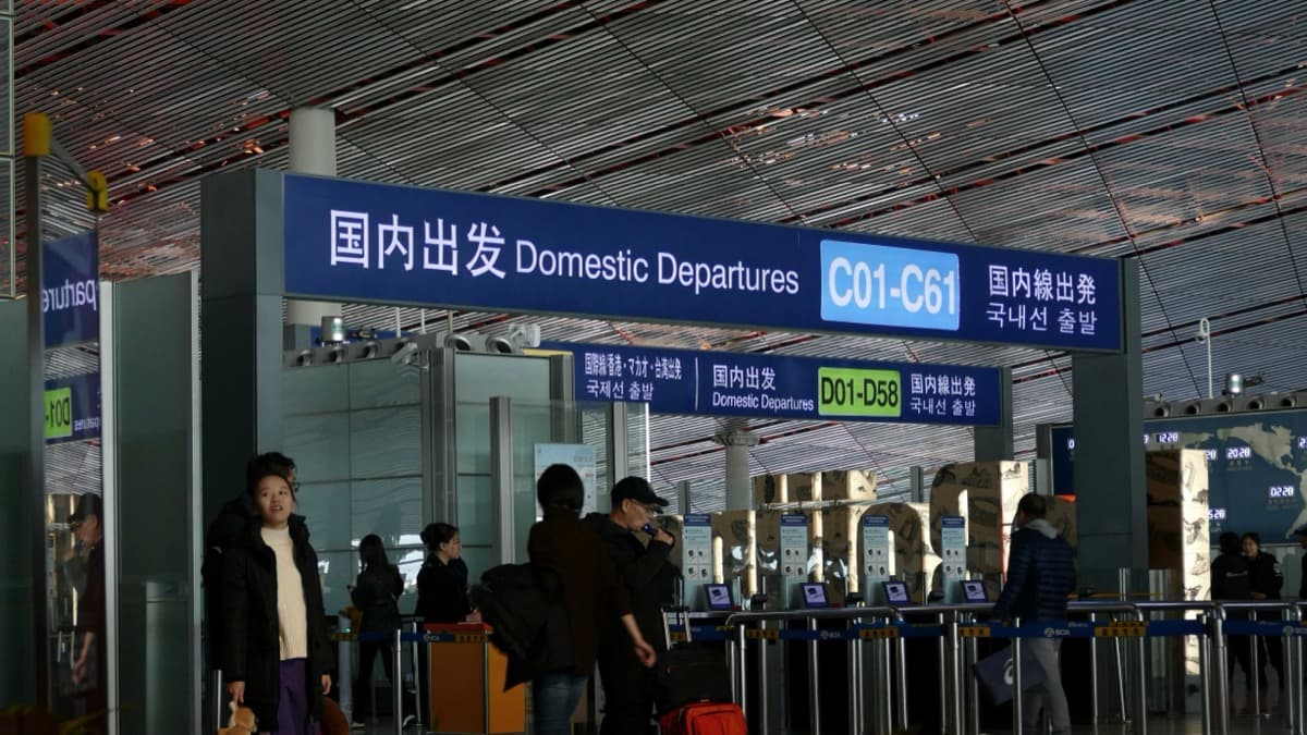 Entrée des départs intérieurs dans un aéroport chinois avec une signalétique bilingue chinois-anglais et des numéros de portes